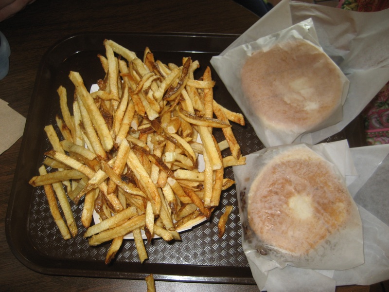 Two counter-service burgers with fries on trays