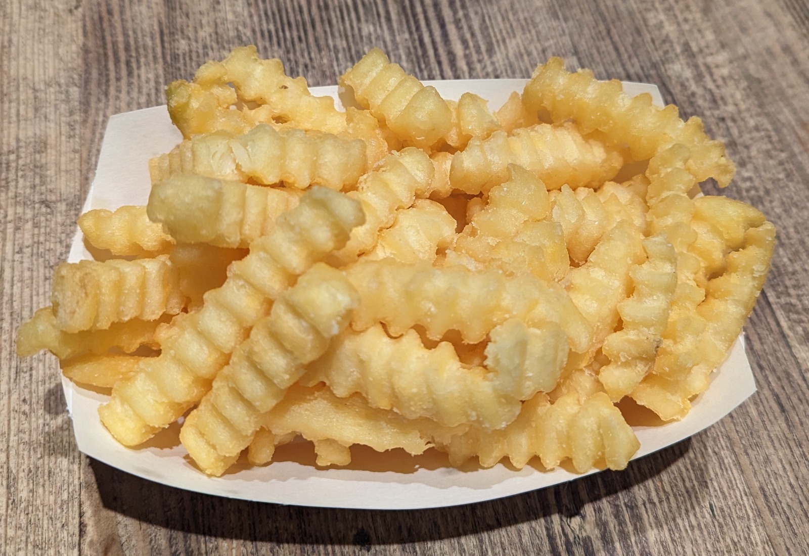 Golden crinkle-cut french fries with ridged surfaces